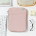 Close-up of pink 11-inch shockproof tablet sleeve with front pocket on white desk - 11" / Pink
