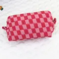 Nahaufnahme einer rosa-rot karierten Strick-Kosmetiktasche mit weicher Wolltextur - Rosa Karomuster / Rot