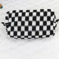 Nahaufnahme einer schwarz-weiß karierten Strick-Kosmetiktasche mit feiner Textur. - Schwarz