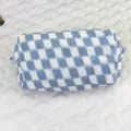 Nahaufnahme zeigt die weiche Strickstruktur der blau karierten Kosmetiktasche im Detail - Blau