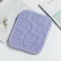 Detail view of a lavender quilted floral iPad sleeve with zipper on a desk - 24*2*30cm / Violet