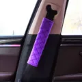 Macro view of purple plush car seat belt cover featuring a quilted rhombus design pattern. - Purple