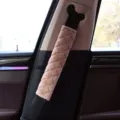 Close-up detail of a pink quilted plush seat belt shoulder cover installed in a car. - Coffee