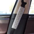 Detail view showing the soft texture and diamond quilting of a grey car seat belt pad - Smoky Gray