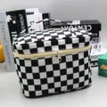 Close-up of black and white checkerboard cosmetic bag with sturdy top handle and zipper - Cosmetic Bag - Black White Grid