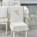 Close-up detail of cream quilted dining chair cover with elegant floral fan embroidery - Auspicious Beige