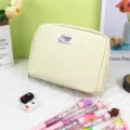 Crème canvas pennenzak met Lucky Day label en kleurrijke pennen op wit oppervlak - Broken Wit