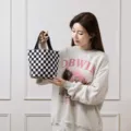 Clásico bolso tote de pana a cuadros blancos y negros con una modelo femenina asiática - Nuevo bolso de mano de pana a cuadros en blanco y negro