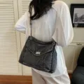 Sac à bandoulière en denim délavé moderne doté d'une chaîne argentée et d'un fermoir en métal - Noir