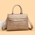 Elegant taupe crocodile pattern handbag featuring a decorative golden flower clasp lock - Khaki