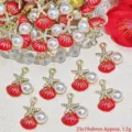 Macro view of red enamel shell jewelry charms featuring faux pearl and gold starfish accents. - 海星珍珠贝壳(G994) / Red