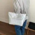 Elegante borsa tote bianca in PVC a doppio strato con raffinati motivi floreali traforati. - Bianco