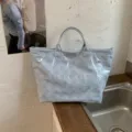 Light blue double-layer PVC tote bag with hollow flower patterns and TOTE BAG print. - Blue