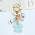 Detailed view of medical nurse themed keychain with light blue enamel hat and scrub charms - Blue