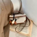 Elegante bolso tipo caja de lona y cuero con colgante de caballo alado en crema y café. - Sin colgante / Marrón
