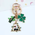 Close-up of a gold panda keychain with bamboo and green four-leaf clover charms - Red Flower Panda