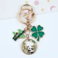 Detailed view of a cute Chinese-style panda keychain with bamboo and clover charms - Holding Bamboo Panda