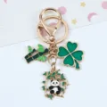 Close-up detail of a cute panda keychain featuring bamboo and green clover charms - Bamboo Leaf Panda