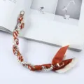Detail van een polsbandje voor mobiele telefoon van parels en oranje zijden sjaal met goud - Oranje Wit Twill Strik Stijl (K176-9)