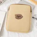 Close-up detail of the cute embroidered cat face on a beige padded tablet laptop sleeve case - 11" / Off White