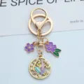 Vue détaillée de charms sur le thème de l'océan sur un porte-clés doré et perles - Fleur de Perle Violet