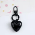Close-up detail of a glossy black resin heart keychain with matching black metal hardware - Black