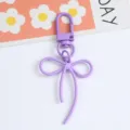 Detailed macro view of a stylish purple alloy bow keychain pendant for bags and accessories - Purple