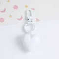 Detail view of a glossy white candy-colored resin heart-shaped keychain pendant - White