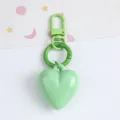 Macro view of a mint green candy-colored resin heart keychain with matching carabiner hooks - Light Green