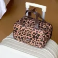 Leopard-Muster PU Kosmetiktasche auf einem Koffergriff in einer Reiseszene - Brauner Leopard