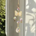 Elegante acchiappasole a farfalla in cristallo che riflette luce iridescente sulla finestra - Stile Farfalla