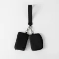 Primer plano de dos mini bolsas negras con cremallera sujetas a una muñequera - Negro + Negro