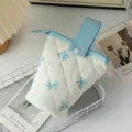 Gros plan détaillé du motif de nœud matelassé sur la trousse à crayons bleue et blanche - Fond Blanc Nœud Bleu