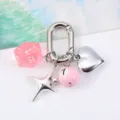 Detail view of pink multi-sided dice and silver heart charms on a sturdy keychain - Pink