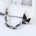 Detailopname van een telefoonriem met parels en gestreepte zijden sjaal met gouden clips - Klassieke Zwart Witte Strepen (K176-20)