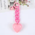 Nahaufnahme eines rosa Acryl-Herz-Schlüsselanhängers mit grober Kette - Rosa