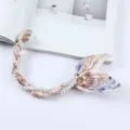 Detailweergave van het elegante parel- en zijden sjaaltelefoonkoord met gouden clips - Abstracte Printstijl (K176-21)