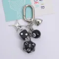 Detailed macro shot of creative black dice and billiard 8-ball keychain with silver charms - Black
