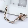 Detailopname van bloemen zijden sjaal en parelmoer telefoonkoord met gouden metalen clips - Retro Bloemenstijl (K176-23)
