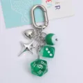 Detail view of lucky green dice and silver heart charms on an ins-style metal keychain - Green