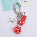Detailed view of lucky red dice and billiard ball charms on a silver heart keychain - Red