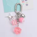 Macro view of creative pink lucky dice and heart charms on a silver keychain detail - Pink