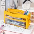 High-capacity yellow mesh pencil case shown in a study scene with desk accessories - Regular / Yellow