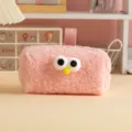 Close-up of a pink plush pencil case featuring cute large cartoon eyes and a yellow nose - Pink