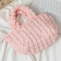 Vista detallada de un bolso rosa con textura de burbujas sobre una tela blanca suave - Rosa
