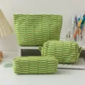 Close-up of green and cream knitted striped cosmetic bag set on white desk surface - Three-Piece Set / Beige and Green Stripes