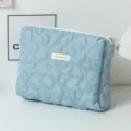 Detailed view of blue quilted cosmetic bag featuring large flower patterns and top zipper - 24*20*6cm / Blue