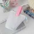 Astuccio verticale bianco portatile con manico rosa e cerniera blu su scrivania bianca - Azzurro