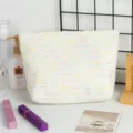 Détail d'une trousse de maquillage tissée avec des rayures pastel dans un décor - 26*6*18cm / Blanc