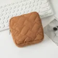Detail einer braunen gesteppten Kosmetiktasche auf einem weißen Schreibtisch-Setup - 12.5*12.5*5cm / Dunkelbraun